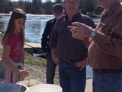 Hatchery member John Hetherington explains to the students the process at the dock with the male and female pickerel ( Brave man)