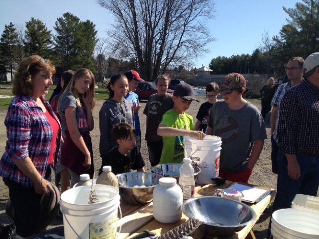 ACHP Learning Center students at the dock helping stir the fertilized eggs before being transferred to the hatchery containers